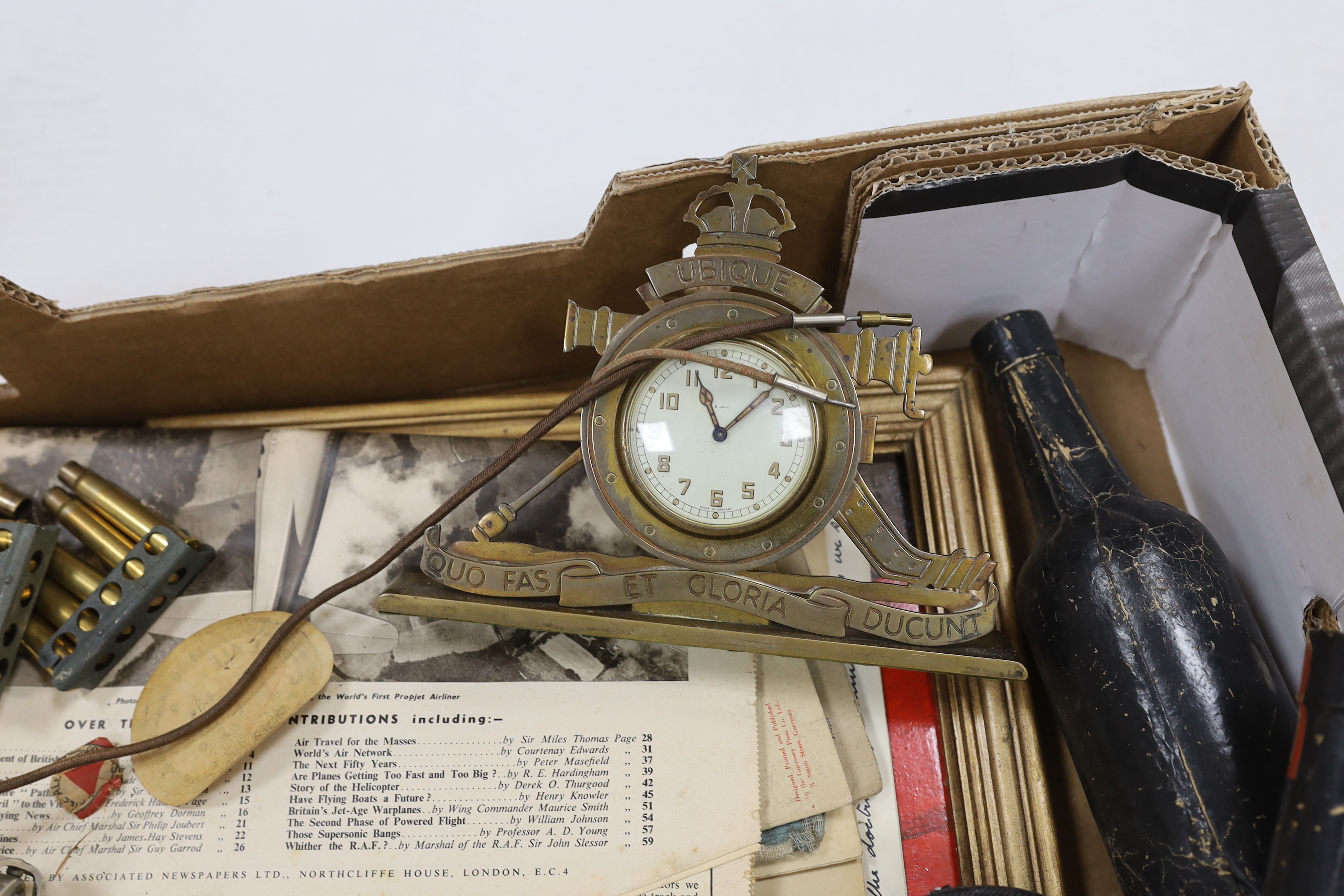 A collection of Militaria and other items, including a Royal Artillery brass cased timepiece, headphones, crepe paper bunting contained in a card Worthington’s IPA beer bottle, etc.